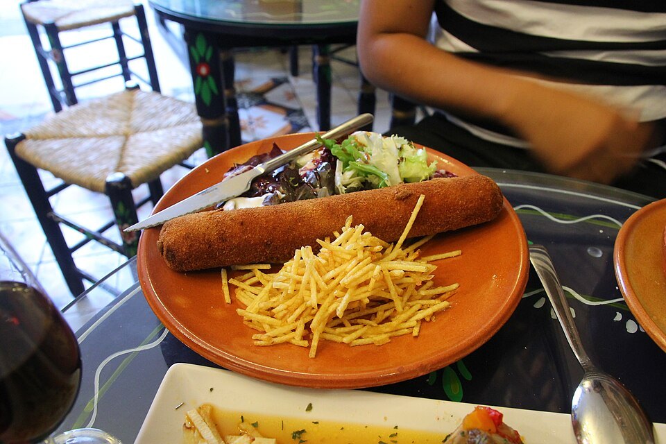 Flamenquín — pork rolled around ham, breaded and fried, served by the length.
